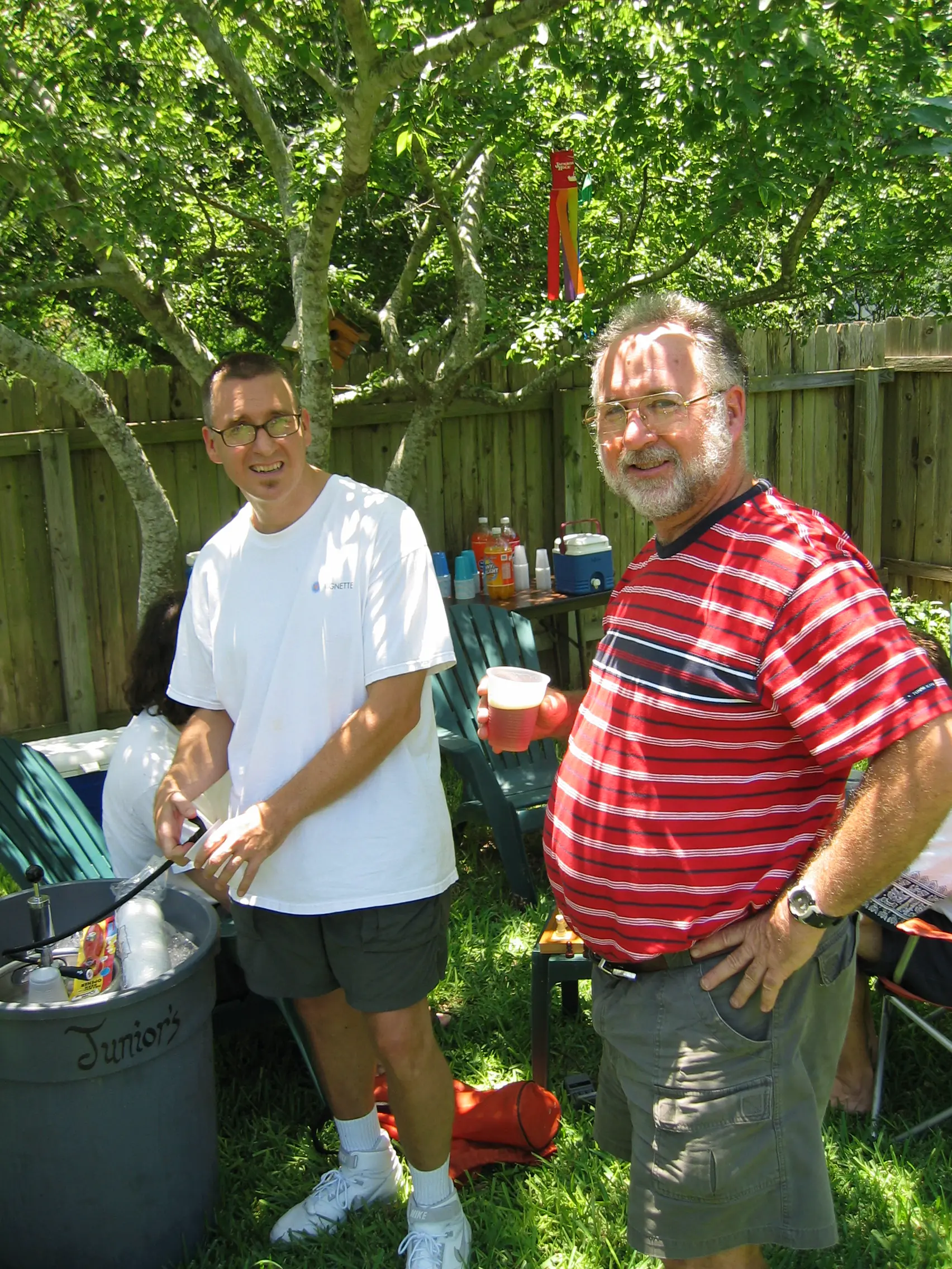 Joe at the keg with a friend in a red striped shirt at his backyard birthday party