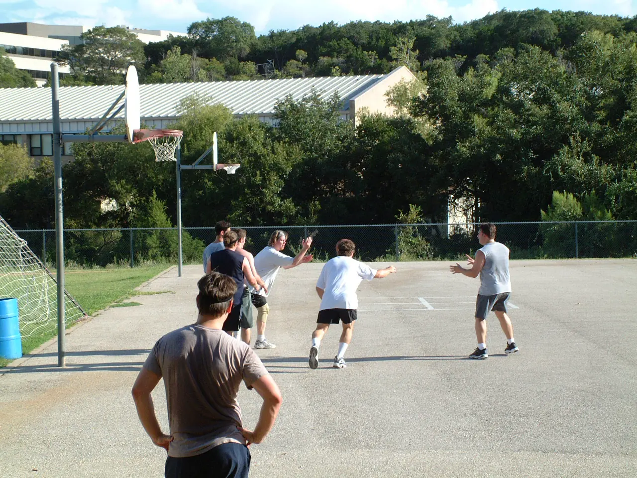 Players spread across an outdoor court mid-game as one throws a pass